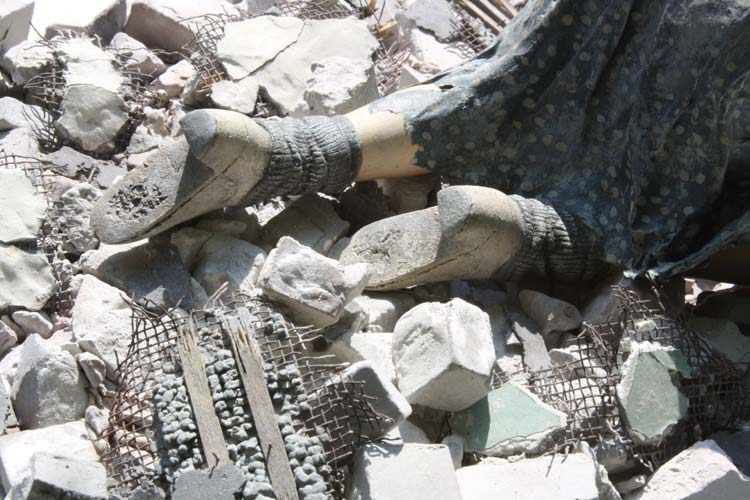 detail of worn out shoes in rubble